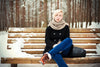 Depressed woman with winter blues sits on a snowy park bench